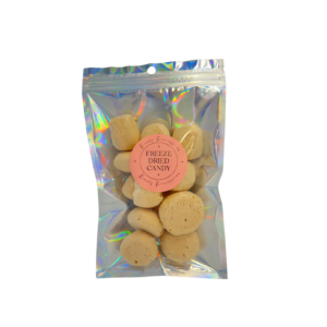 Honey bits are featured in a mylar bag with a clear front cover, showcasing the airy, textured, tan candies.